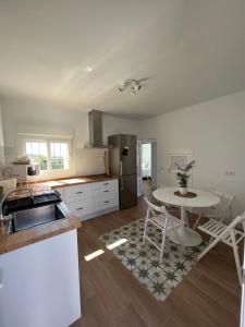 a kitchen with a table and a refrigerator and a table at Villa Mariaje in Cazalla de la Sierra +10 photos