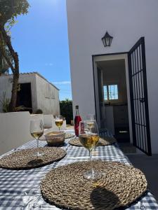 una mesa con dos copas de vino blanco. en Villa Mariaje, en Cazalla de la Sierra