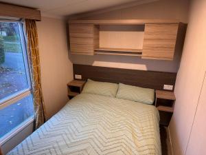 a small bedroom with a bed and a window at 3BR-Sleeps6-Parking-Pool-NearBeach&Skegness in Skegness
