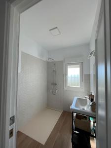 baño blanco con lavabo y ventana en Villa Mariaje, en Cazalla de la Sierra