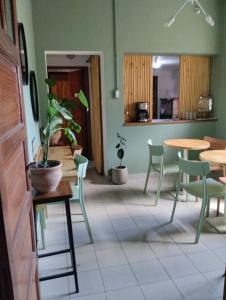 a dining room with tables and chairs and a plant at Hostel Ruta76 in Sierra de la Ventana