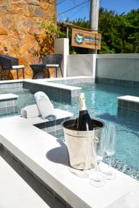 a bottle of champagne in a bucket next to a swimming pool at Pousada Bahia Inn in Morro de São Paulo