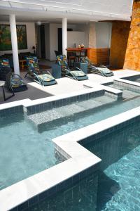 a swimming pool with chairs in a hotel room at Pousada Bahia Inn in Morro de São Paulo