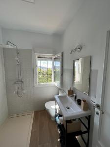a bathroom with a sink and a toilet and a window at Villa Mariaje in Cazalla de la Sierra