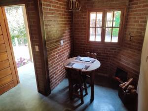a small table in a room with a brick wall at Chalé do Bosque in Visconde De Maua