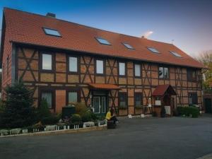a woman sitting in front of a building at Mühlenberg Hof in Wolfsburg