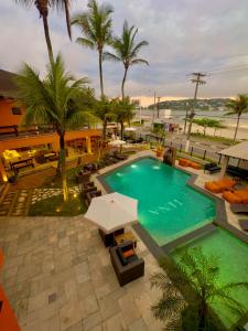 an overhead view of a swimming pool with palm trees at Luna Hotel Boutique - Frente à Praia in Guarujá