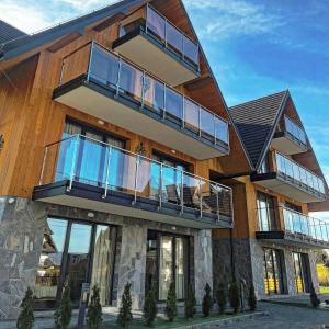 ein Gebäude mit Balkonen an der Seite in der Unterkunft NOWE APARTAMENTY GÓRALSKIE BIAŁKA - SkiBus, Sauny, Bania, Sale Zabaw - w cenie in Białka Tatrzańska + 42 Fotos