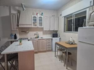 a kitchen with white cabinets and a white refrigerator at Large chalet 5 min walk to beach in Vélez-Málaga