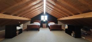 a attic room with two beds and a window at Casa do Vô Sousa in Pombal