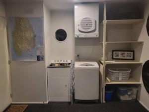 a small kitchen with a stove and a refrigerator at Remarkable Views 3 bedroom - lake & mountain views in Queenstown