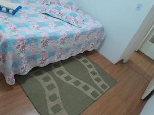 a bedroom with a bed and a rug on the floor at Lar feliz in Juiz de Fora