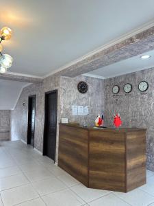 a lobby with a counter and clocks on the wall at Hotel Ritur Mestia in Mestia