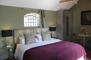 a bedroom with a large bed with a purple blanket at Hayeswood Lodge Luxury Accommodation in Stanley