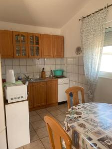 eine kleine Küche mit Tisch und Mikrowelle in der Unterkunft Apartment Tihana in Vir
