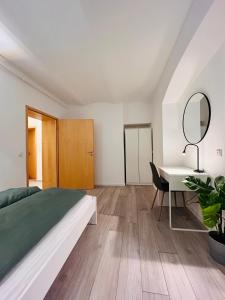 a bedroom with a bed and a desk and a mirror at Gemütliches Apartment - beste Lage in Kassel