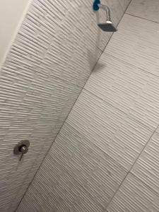 una ducha en un baño con techo de metal en Hostal Low Cost, en Santiago