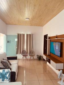 a living room with a couch and a flat screen tv at Casa por temporada Bhs in Barreirinhas