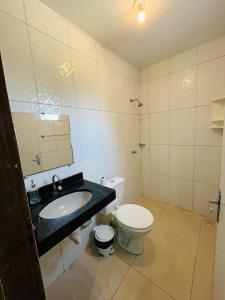 a bathroom with a toilet and a sink at Casa por temporada Bhs in Barreirinhas