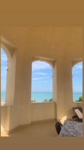 2 okna w pokoju z widokiem na ocean w obiekcie Villa Giada w mieście Trani