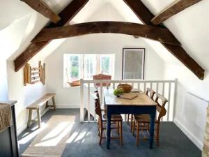 a dining room with a wooden table and chairs at The Hopps - New, Stylish Loft in Gloucestershire