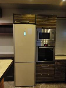 a kitchen with a refrigerator and a microwave at Apartament ''Cleopatra'' z garazem podziemnym, faktury VAT in Kielce