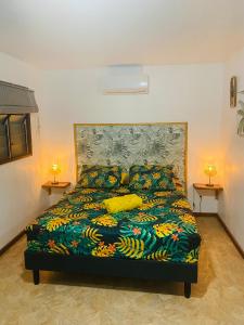 a bed in a room with two lamps on two tables at Huahine Serenity Cottage in Maroe