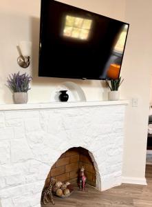 a tv over a fireplace with a tv above it at The House Hotels - Henninger Lower V1 in Cleveland