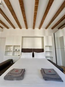 a bedroom with a white bed with two towels on it at Gold’s house in Trieste