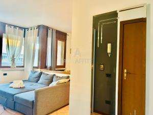 un soggiorno con un divano blu e una finestra di Orchidea Apt - 3 Piscine e un Bar a 200m dal Lago a Desenzano del Garda Altre 37 foto
