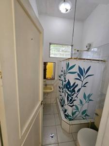 a bathroom with a toilet and a shower curtain at VILLA SANTORO Casa playa de Castelnuovo-Atacames in Atacames