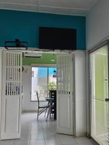 a living room with a table and a flat screen tv at VILLA SANTORO Casa playa de Castelnuovo-Atacames in Atacames