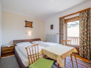 a bedroom with a bed and a table and a window at Schwoichbauer in Saalbach Hinterglemm