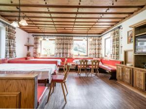 a room with red furniture and a table and chairs at Schwoichbauer in Saalbach Hinterglemm