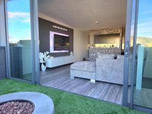 a living room with a couch and a tv at Modern Duplex Penthouse Panoramic Views & Parking in Bradford