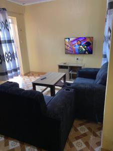 OgemboにあるTsavo Apartments Ogemboのソファ2つとテーブルのあるリビングルーム +2枚の写真