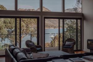 a living room with a couch and some windows at Sentinel at Freycinet in Coles Bay