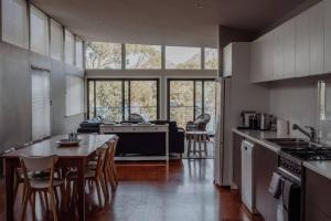 a kitchen and dining room with a table and chairs at Sentinel at Freycinet in Coles Bay