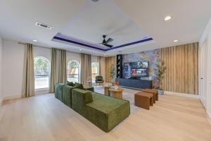 a living room with a green couch and a tv at Pickleball Paradise Retreat - 4 Bedrooms, 2,5 Baths - Houston Downtown, Houston Heights - Pickleball and Basketball Court, Pool, miniGolf, Karaoke, Fire Pit, BBQ, Billiards, Ping Pong, Hockey, King Bed in Houston