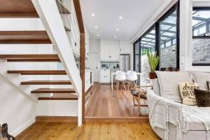 a living room with stairs leading to a kitchen at The Newtown Nest - Managed by X Hospitality in Sydney