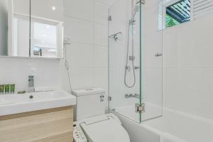 a bathroom with a toilet and a sink and a shower at The Newtown Nest - Managed by X Hospitality in Sydney +15 photos
