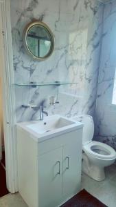 Un baño blanco con lavabo e inodoro. en Mancunian Pride Villa, en Mánchester 99 fotos más