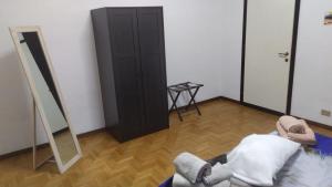 una stanza con un armadio nero e uno specchio di CASA CHIARA - 11 minuti da Milano - 6 minuti da policlinico San Donato Milanese a San Giuliano Milanese