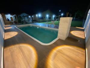 a swimming pool in a backyard at night at Casa bem espaçosa com piscina, campo de futebol e área gourmet a um quarteirão da lagoa de Praia Seca in Araruama