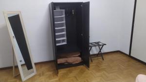 un armadio nero con scaffali accanto a uno specchio di CASA CHIARA - 11 minuti da Milano - 6 minuti da policlinico San Donato Milanese a San Giuliano Milanese