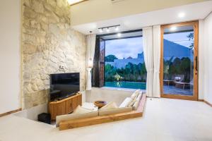 a living room with a large stone wall at Cozy Villa with pool in the center of Ubud in Ubud