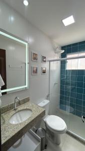 a bathroom with a toilet and a sink and a shower at Apartamento Terra Firme in Rio das Ostras