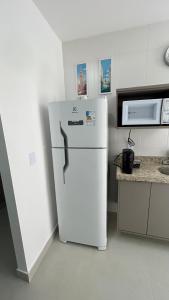 a white refrigerator in a kitchen with a microwave at Apartamento Terra Firme in Rio das Ostras +37 photos