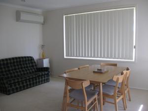 a living room with a table and chairs and a window at Hayden House in Delegate +3 photos