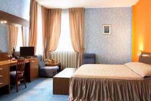 a hotel room with a bed and a desk with a computer at DITER Family Hotel in Sofia